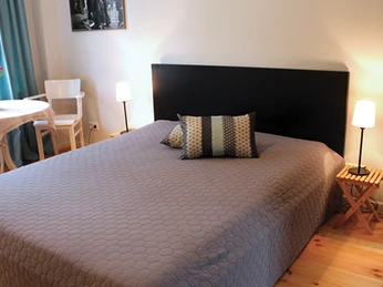 Zimmer in der Fabrikantenvilla in Erkrath Helles Zimmer mit einem großen Bett, Tisch, Stuhl und Lampen, perfekt für gemütliche Erholung.