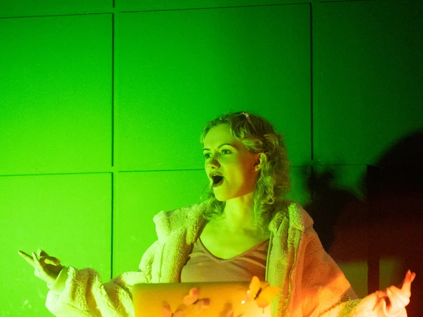 Koelnchella_22.jpg Person an DJ-Pult mit Laptop und bunten Lichtern in grüner und gelber Beleuchtung.