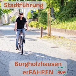 Stadtführung Rädel.jpg Ein Mann fährt bei Sonnenschein auf einem blauen Fahrrad eine schattige Kopfsteinpflasterstraße entlang.