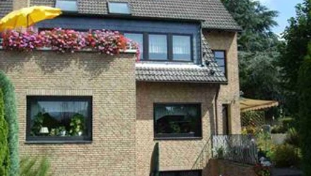 Haus Panorama in Ratingen Modernes zweistöckiges Einfamilienhaus in Ratingen mit Klinkerfassade, bepflanztem Balkon und Garten.