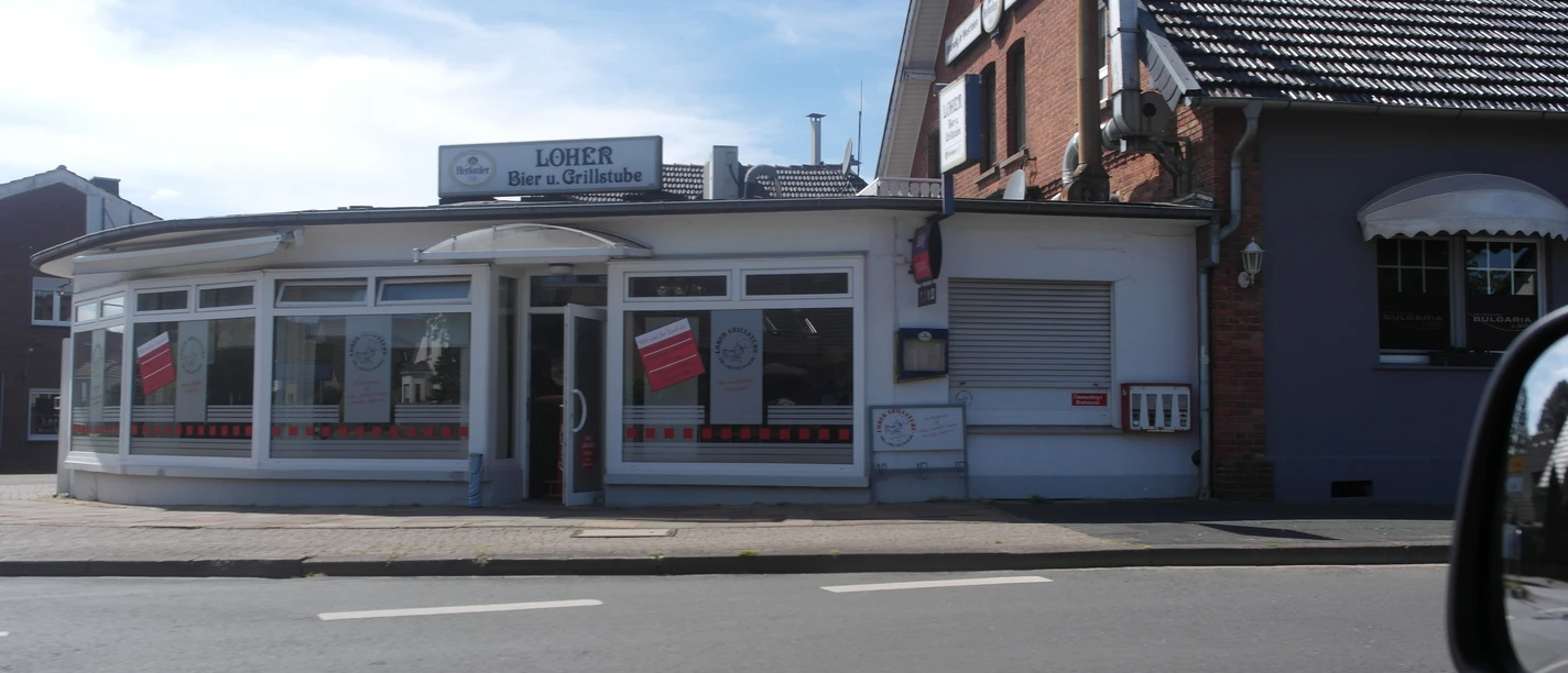 SAM_2019.JPG Auf dem Bild ist die Außenansicht der Loher Grillstube zu sehen. Die Fassade ist weiß und schlicht.