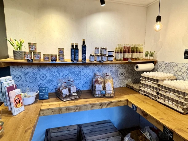 HOF.echt Hofladen Fam. Theissing in Salzbergen ©Emsland Tourismus GmbH (3).jpg Holzverkaufstheke mit Eiern, Brot, Säften und regionalen Produkten in einem modernen Hofladen