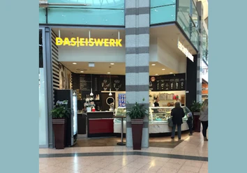 DasEiswerk2.png Das Bild zeigt das Eiswerk im Werre-Park. Rechts erkennt man die Theke an der zwei Personen eine Bestellung abgeben. Links sieht man einen Kühlschrank und weitere typische Utensilien, die zu einer Eisdiele gehören.