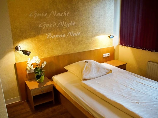 Hotelzimmer im Hotel Alberga in Mettmann Ein gemütlich eingerichtetes Einzelzimmer im Hotel Alberga in Mettmann mit heller Holzmöblierung und einem Einzelbett.