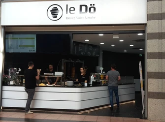 LeDö Ein Imbissstand mit dem Namen "LeDö", der Döner, Salate und mehr anbietet. Kunden stehen davor.