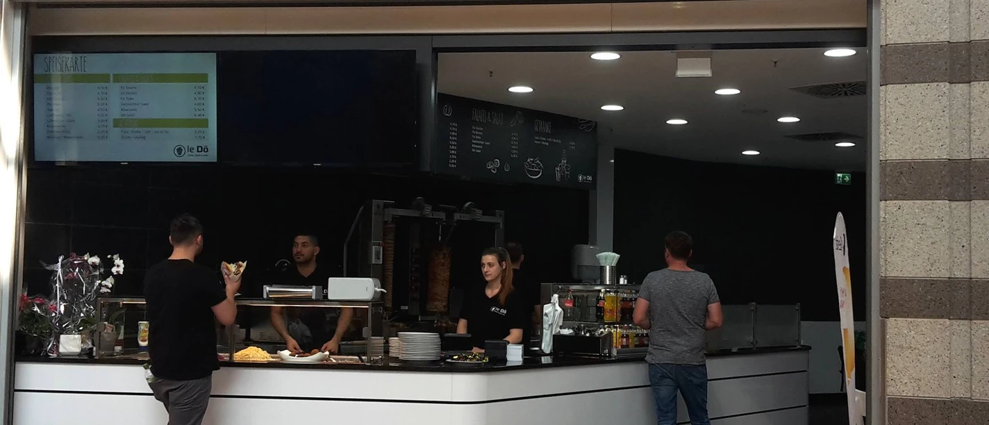 LeDö Ein Imbissstand mit dem Namen "LeDö", der Döner, Salate und mehr anbietet. Kunden stehen davor.