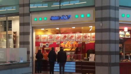 pp.jpg Zu sehen ist der Potato Point im Werre-Park, vor dem sich eine lange Schlange gebildet hat. Die Einrichtung des Imbisses ist in auffälligen Farben wie Gelb und Rot gestaltet. An der Wand hängen zahlreiche Tafeln, die verschiedene Gerichte beschreiben und die Auswahl noch verlockender machen.