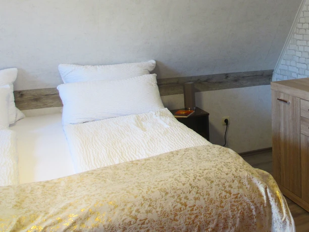 Slaapkamer met boxspringbed in de vakantiewoning Anne
