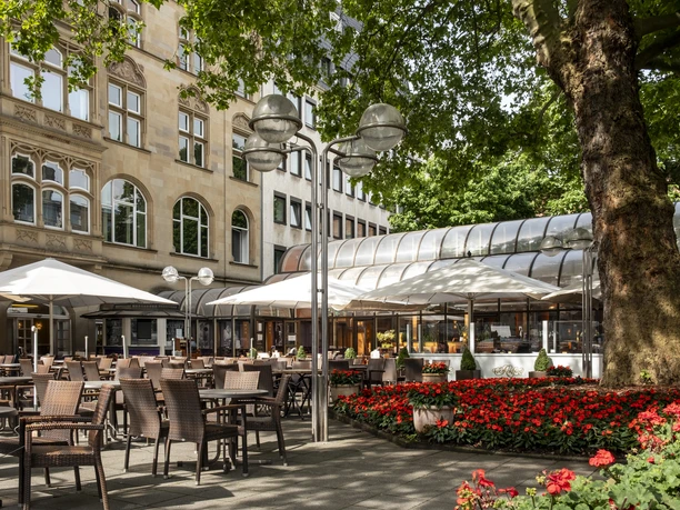Cafe Reichard Großzügige Terrasse mit bunten Blumen und vielen Sitzmöglichkeiten zum Essen.