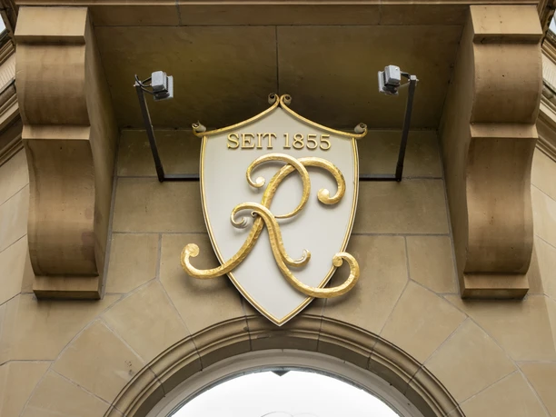 Cafe Reichard Eingang zum Cafe mit prunkvoll verziertem Schild mit goldenen Buchstaben.