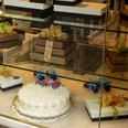 Cafe Reichard Vitrine mit schön verzierten Präsenten und üppiger Torte mit Marzipandekor. Display case with beautifully decorated presents and a lavish cake with marzipan decoration.