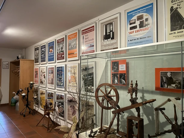 Landwirtschaftsmuseum Rhede (Ems) Ausstellungsraum mit historischen Spinnrädern, landwirtschaftlichen Geräten und alten Plakaten an der Wand