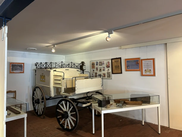 Landwirtschaftsmuseum Rhede (Ems) Ausstellungsraum mit historischem weißen Pferdewagen, Informationstafeln und Glasvitrinen im Museum.