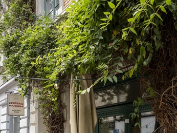 Epicerie Boucherie Kleine Tische mit zwei Stühlen stehen vor dem Cafe. There are small tables with two chairs in front of the café.
