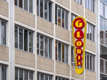 Gloria Das Bild zeigt das mehrstöckige, moderne Gebäude des Gloria-Theaters in einer Innenstadtlage.The picture shows the multi-storey, modern building of the Gloria Theater in a city center location.