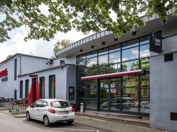 Herbrand's Exterior view of the Herbrands with large glass front and bicycle racks in front of it.