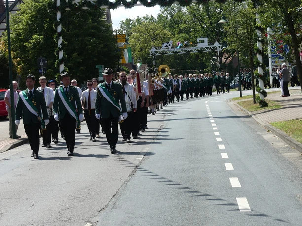 Festumzug.JPG Festumzug beim Schützenfest in Bispingen: Menschen in grünen Uniformen auf der Straße.