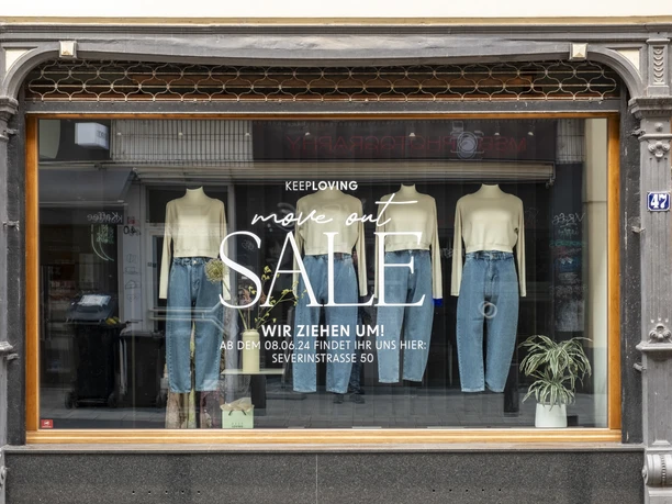 Keep Loving Schaufenster eines Geschäfts mit der Botschaft "Keep Loving. Move out. Sale.
