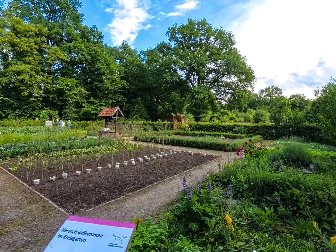 Der Kräutergarten der Biologischen Station Nordholz mit üppigem Grün, Kräuterbeeten und Schautafeln.