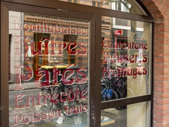 Maison Blue Blick auf die Fenster mit verschnörkelter Schrift.View of the windows with ornate lettering.