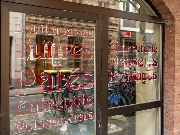 Maison Blue View of the windows with ornate lettering.
