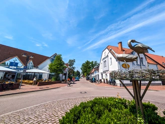 Innenstadt Petershagen Stadtstraße in Petershagen mit Fachwerkhäusern, Fahrradfahrern, Caféterrasse und blumigen Kreisverkehr.