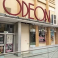 Odeon Das Odeon Kino zeigt eine stilvolle Eingangsfassade mit großen Fenstern und einem markanten rotem Schriftzug.