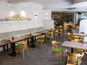 Oshos Place Im modernen Café Sierra mit Holzmöbeln und heller Wanddekoration herrscht eine einladende Atmosphäre.The modern Café Sierra, with its wooden furniture and bright wall decorations, has a welcoming atmosphere.