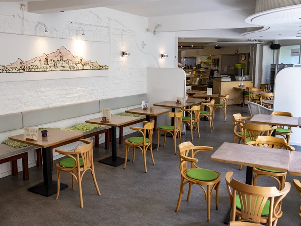 Oshos Place The modern Café Sierra, with its wooden furniture and bright wall decorations, has a welcoming atmosphere.