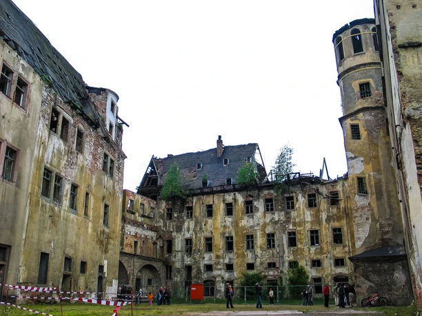 zwickau-osterstein-und-kornhaus-mai-2006-03-c-mattrose-de.jpg Verfallenes Schloss mit historischem Kornhaus, brüchige Mauern und Ruinenform im Vordergrund.