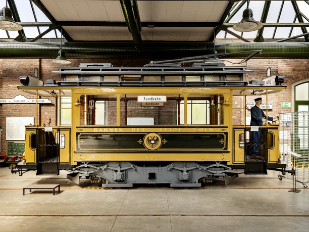 Thielenbruch Tram Museum Historic streetcar in a brick hall with a conductor in uniform. Pure retro charm.