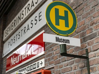 Straßenbahn-Museum Thielenbruch Straßenschilder und ein Haltestellenschild „Museum“ an einer Ziegelmauer.