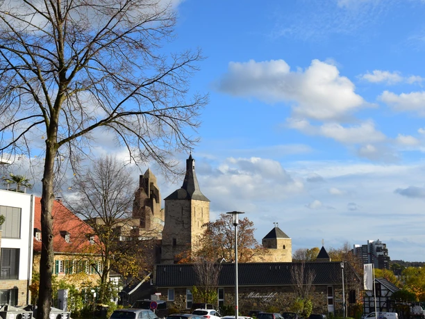 Rathaus Bensberg Ansicht von Bergisch Gladbach mit historischer Kirche und modernen Gebäuden unter blauem Himmel.