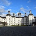 Schloss Bensberg <p>Barockes Schloss Bensberg mit weißen Fassaden und Türmen unter blauem Himmel, Kopfsteinpflaster im Vordergrund.</p>