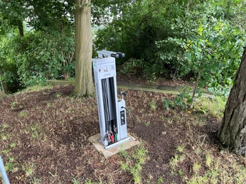 Rastplatz Heimsen Eine Fahrrad-Service-Station steht im Grünen, umgeben von Bäumen und bietet Werkzeuge zur Reparatur.