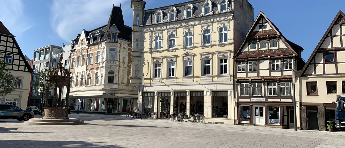 IMG_5549.JPG Historische Gebäude umrahmen einen ruhigen, gepflasterten Platz bei strahlend blauem Himmel.