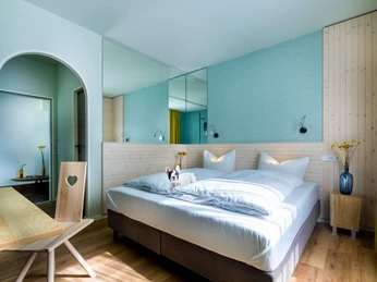 Hotelzimmer im Gartenhotel Fettehenne in Erkrath Helles Hotelzimmer mit modernem Doppelbett, Holzmöbeln und dekorativen Details.