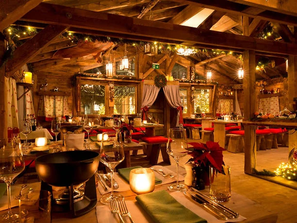 Das Chalet-Almzauber by Wasserturm Hotel Cologne Inside a mountain hut, the tables are laid for a fondue dinner.
