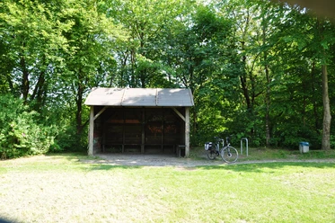 DSC_0438.JPG Überdachter Unterstand im Wald mit gepflastertem Boden, daneben ein angelehntes Fahrrad.