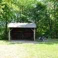 DSC_0438.JPG Überdachter Unterstand im Wald mit gepflastertem Boden, daneben ein angelehntes Fahrrad.