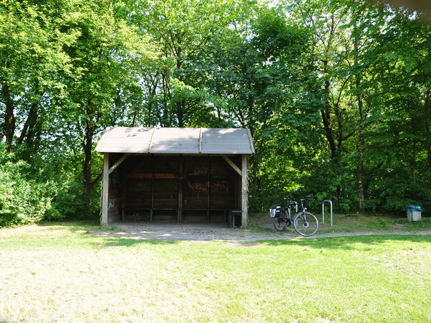 DSC_0438.JPG Überdachter Unterstand im Wald mit gepflastertem Boden, daneben ein angelehntes Fahrrad.