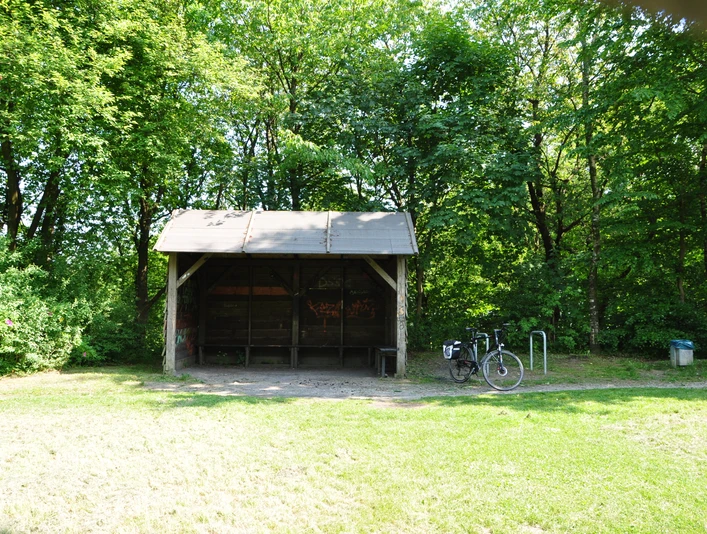 DSC_0438.JPG Überdachter Unterstand im Wald mit gepflastertem Boden, daneben ein angelehntes Fahrrad.
