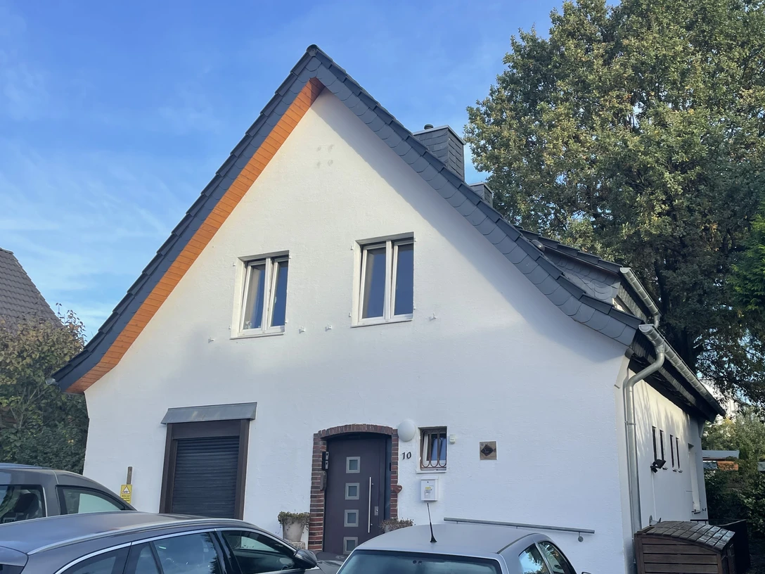 Ferienwohnung Henry´s Oak am Lönsweg 10 in Mettmann Ein modernes weißes Haus mit zwei Fenstern, grauem Dach und einer Haustür mit Glaseinsätzen in Mettmann.