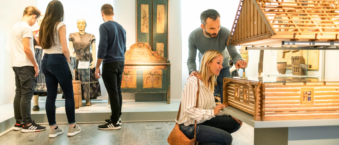 sorbische-museum-7-tobias-ritz.jpg Besucher betrachten Exponate und ein Modellhaus in einem Ausstellungsraum des Sorbischen Museums.