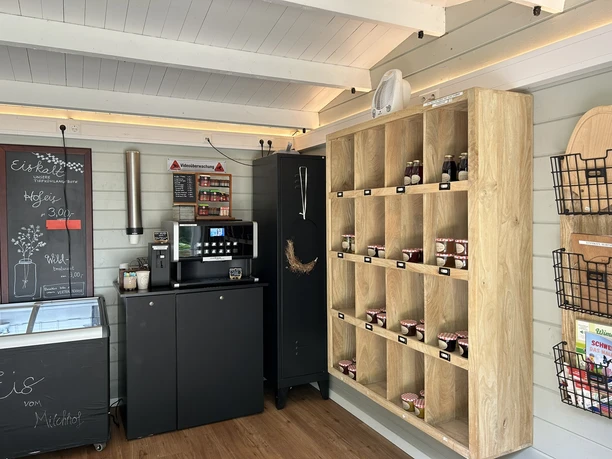 Hof Pleus-Pigstop, Bawinkel ©Emsland Tourismus GmbH (9).JPEG Selbstbedienungsraum mit Kaffeeautomat, Eistruhe und Holzregal voller regionaler Produkte.