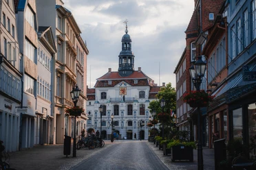 Blick auf das Lüneburger Rathaus Blick auf das historische Rathaus Lüneburg. Kopfsteinpflaster, Blumen, ältere Häuser, ruhige Gasse.