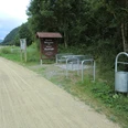CIMG7135.JPG Fahrradabstellplätze und Infotafel am Waldrand neben einem Schotterweg, Mülleimer rechts im Bild.