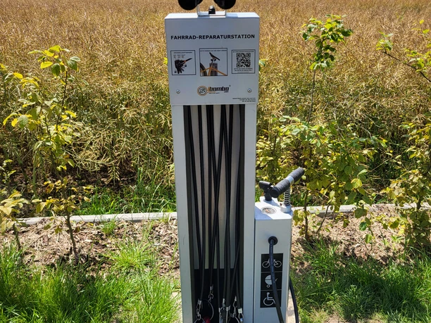 Fahrrad-Reparaturstation in ländlicher Umgebung mit Werkzeugen für kleine Wartungen und Reparaturen.