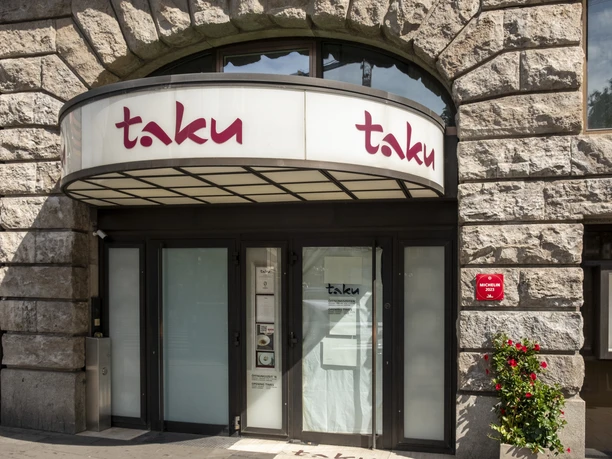 Taku Entrance to Taku restaurant, featuring a modern canopy and stone façade.