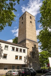 Luther Church High, stone church tower building, square, surrounded by modern buildings and trees.